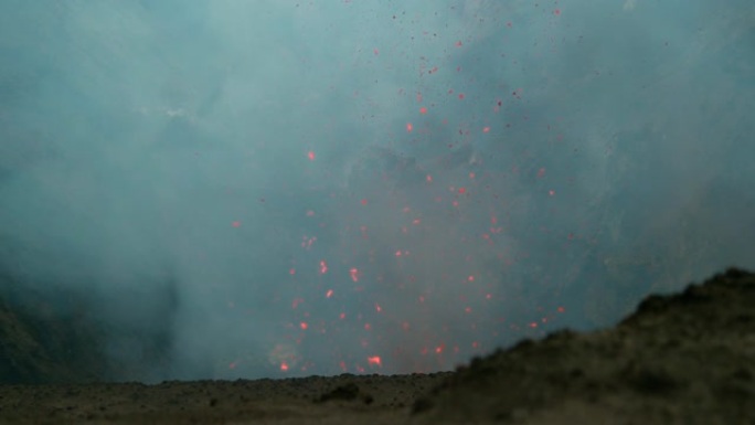 慢动作: 发光的熔岩碎片从活火山中飞出。