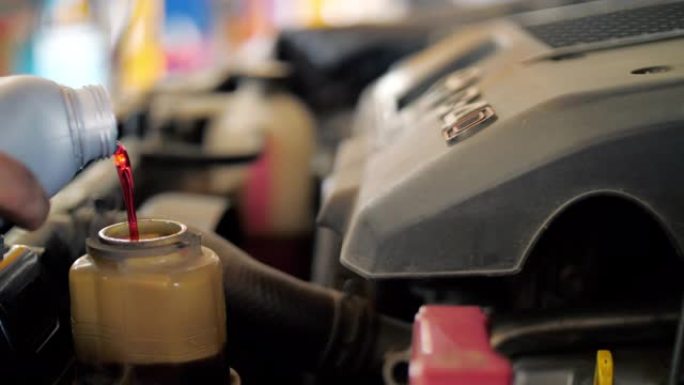 慢动作: 机械工程师将机油更换到发动机中进行维修和保养