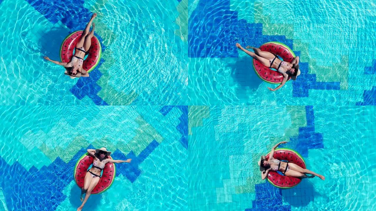 一名妇女在游泳池放松时漂浮在橡胶圈上。
