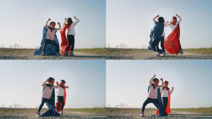 两个有趣的小女孩姐妹打扮成超级英雄的真实镜头，穿着红色和蓝色的舞蹈，玩得开心