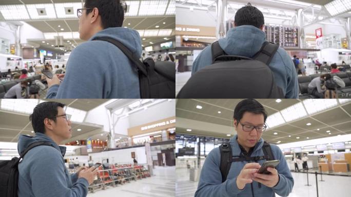 男人用电话看机场的航班时刻表。