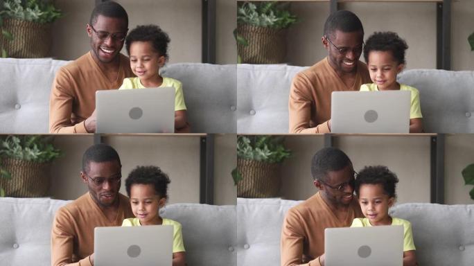 快乐的黑人父亲教孩子儿子阅读使用笔记本电脑
