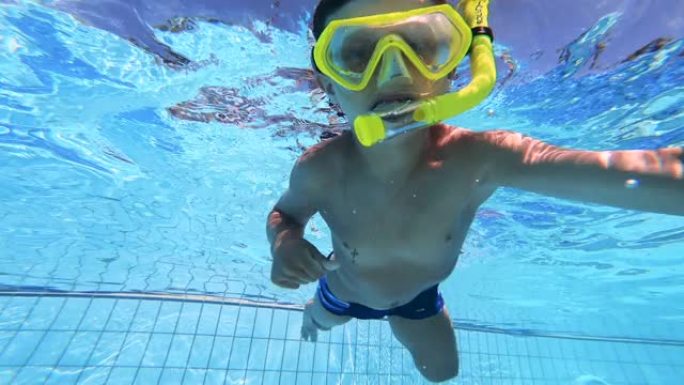 小孩在游泳池里学习游泳时戴着口罩。水下镜头。