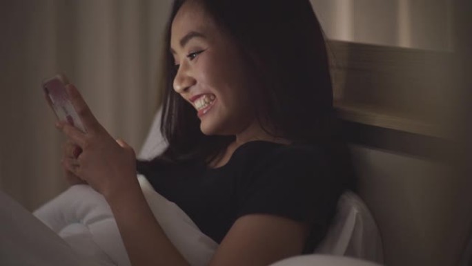 亚洲女性笑脸女性玩手机
