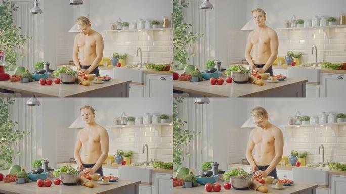 赤膊帅哥用锋利的菜刀切胡萝卜。在现代厨房里准备健康的有机沙拉餐。半裸减肥男对着镜头眨眼。