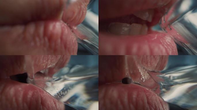 用透明玻璃杯喝水的人的极端近距离拍摄。新鲜的自来水流入口腔内。自然的嘴，洁白的牙齿和红色的嘴唇。