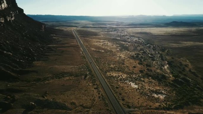 亚利桑那州史诗般的广阔沙漠荒野的电影鸟瞰图无尽的沙漠山谷，汽车沿着高速公路行驶