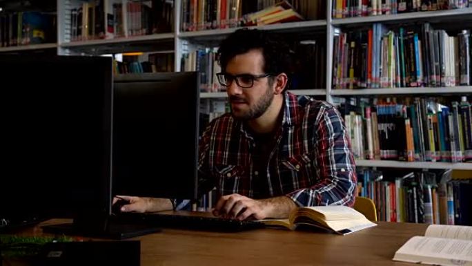 专注的学生在图书馆使用计算机进行论文研究