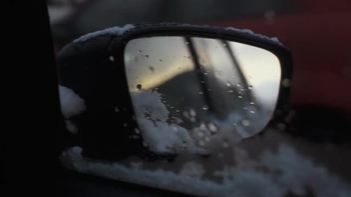 汽车镜子上的第一场雪。特写。