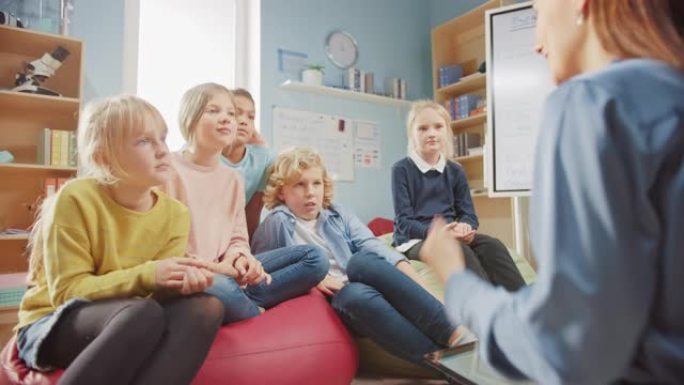 小学创意课: 孩子们坐在地毯上，而有爱心的老师在使用数字平板电脑时讲解课程。在友好的现代环境中学习聪