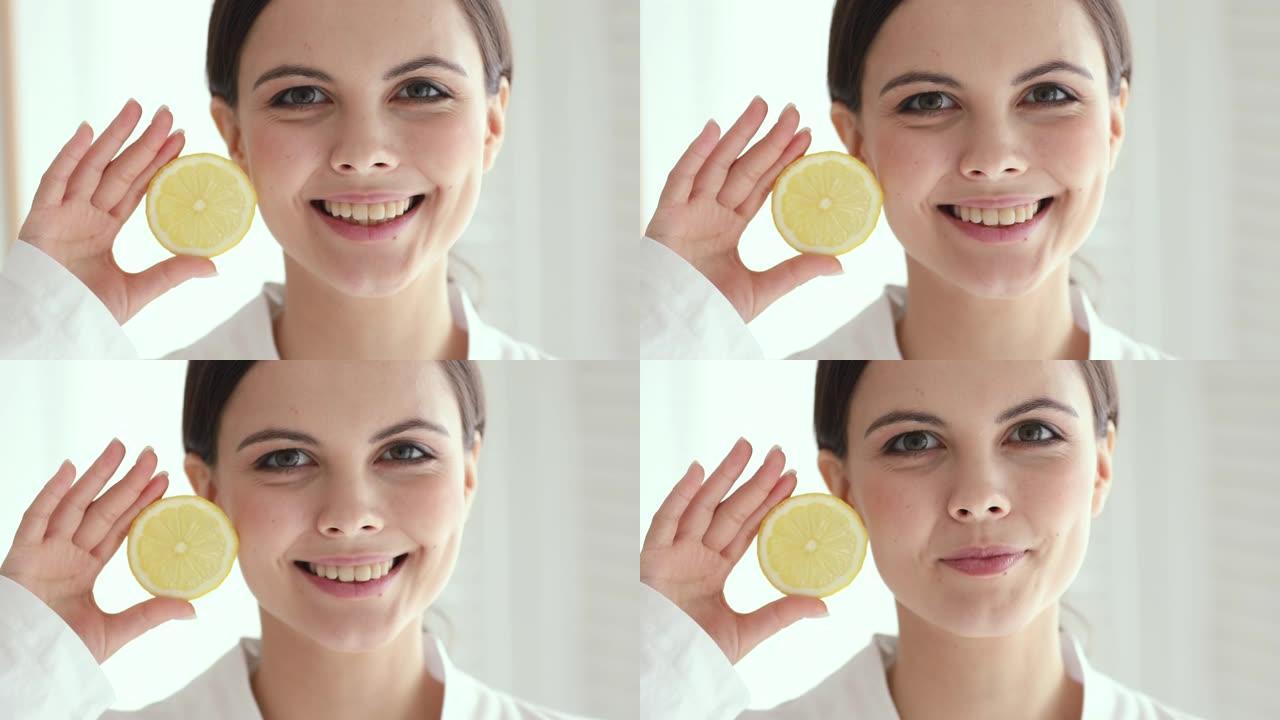 微笑的漂亮年轻女子拿着柠檬看着相机