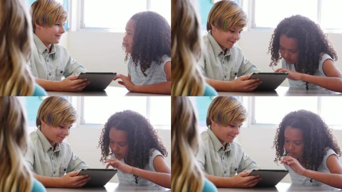 两名学生在学校课程中一起使用平板电脑