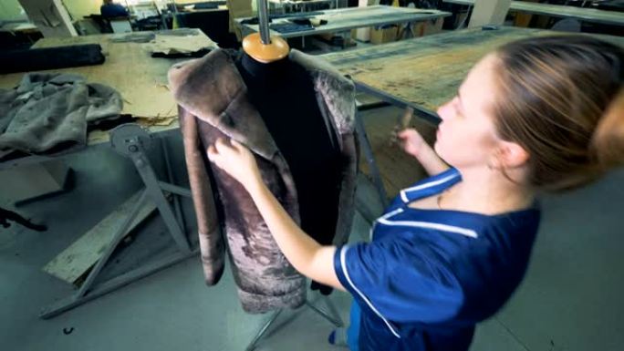 一个女人用刷子清洗皮大衣，特写。