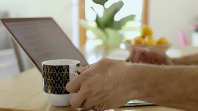 CU人喝茶并在笔记本电脑上工作