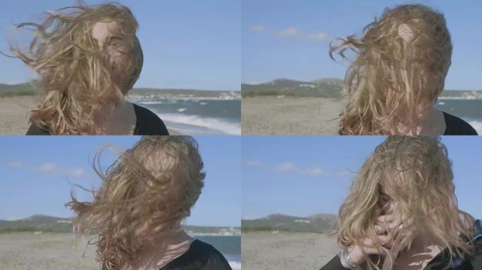 在大风天的海滩上，青少年的头发遮住了脸的慢动作视频