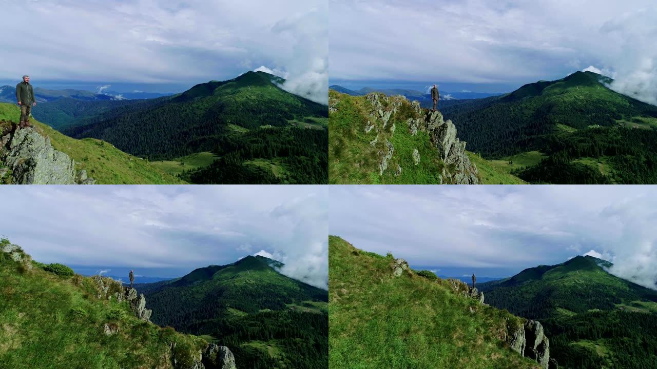 站在山崖上的男人在美丽的风景背景