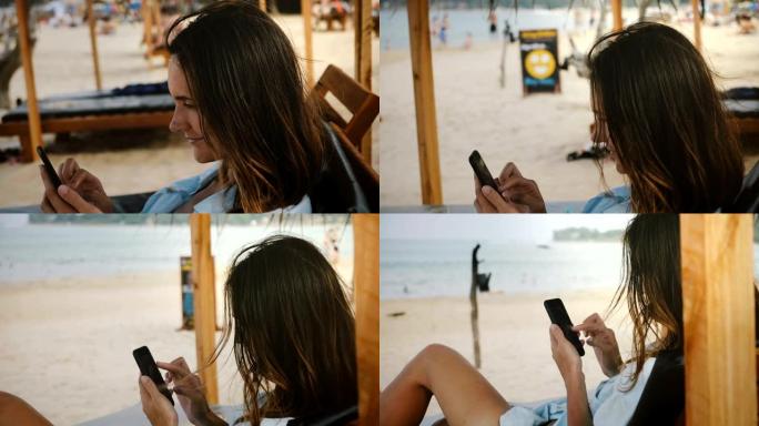 相机在异国度假胜地的躺椅上使用智能手机购物应用程序在快乐的年轻女商人周围移动。
