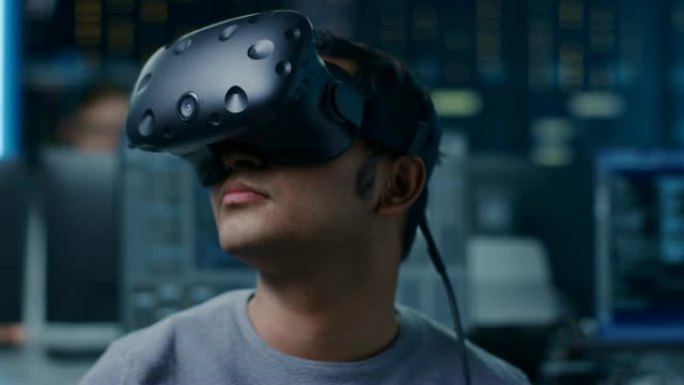 软件Delevoper戴着虚拟现实耳机，用头打手势，开发和编程VR游戏或应用程序。在后台技术开发带有