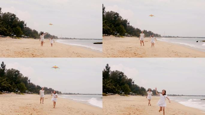 快乐的小女孩放风筝，和年轻的母亲在异国情调的海滩热带度假慢动作中奔向相机。