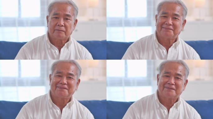 亚洲老人祖父微笑的肖像自信，与相机交流时独自在家里摆姿势，快乐地享受成功的生活方式。在视频会议技术的