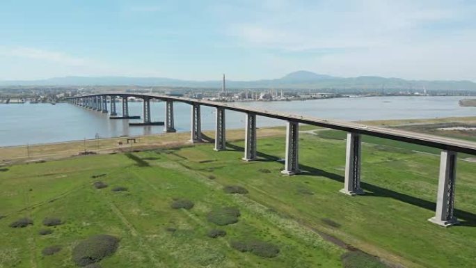 空中飞越广阔的草地，靠近过河的大型混凝土桥