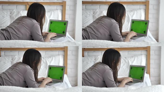 女人在床上使用笔记本电脑绿屏
