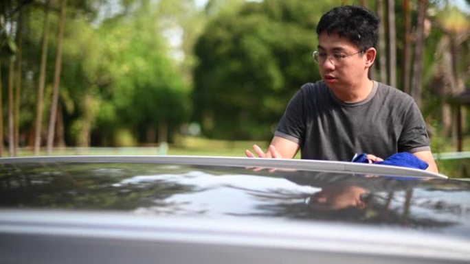 一名亚洲华裔中年男子在家门口洗车