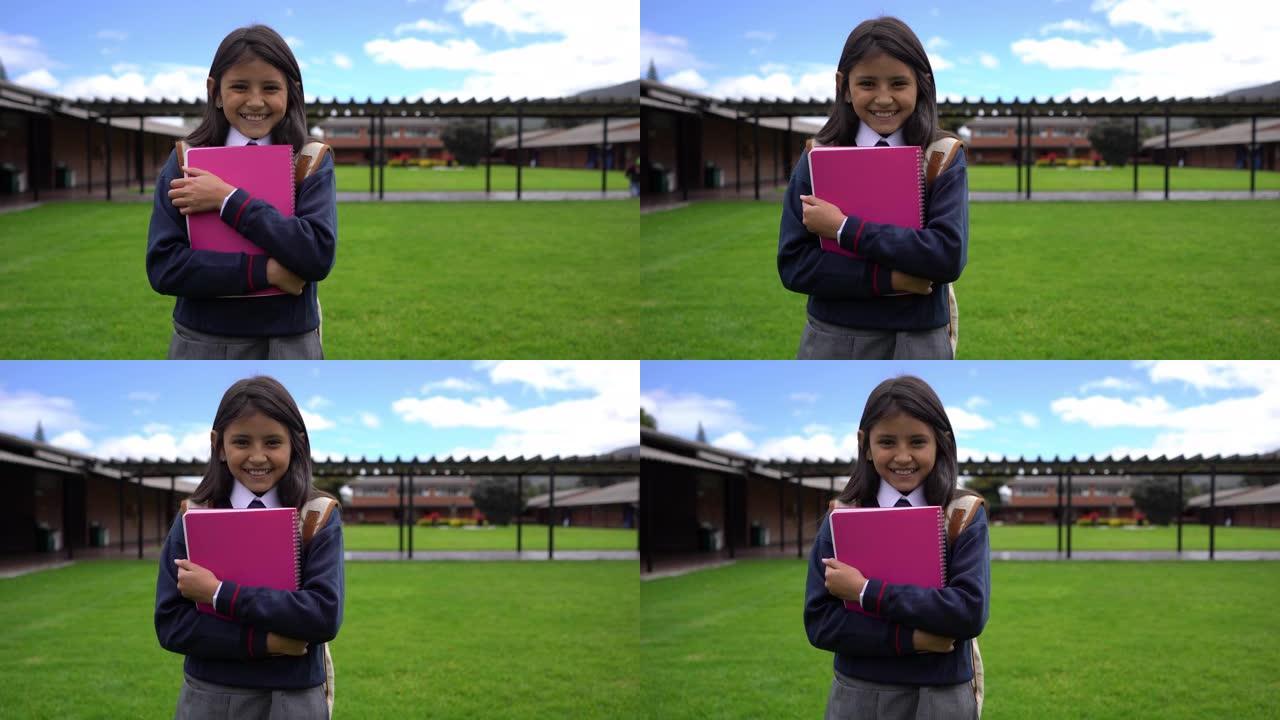 学校里开朗的小女孩拿着笔记本，对着镜头微笑