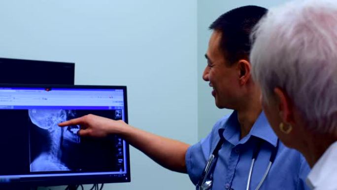 年轻的亚洲男性医生在4k诊所讨论电脑上的x光报告