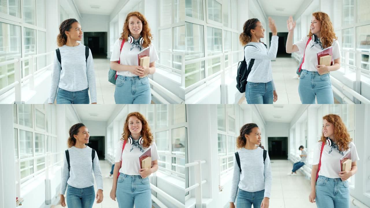 女孩朋友在学校礼堂里散步，拿着书聊天，做高五