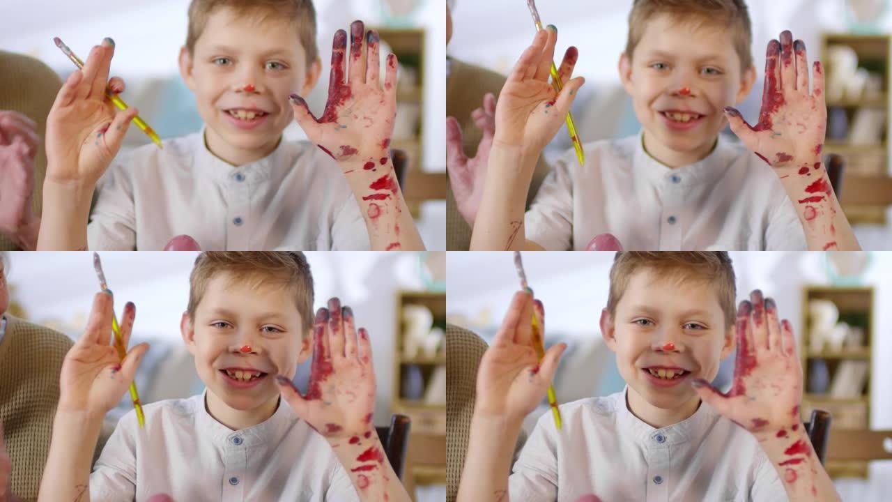 男孩展示双手被油漆覆盖