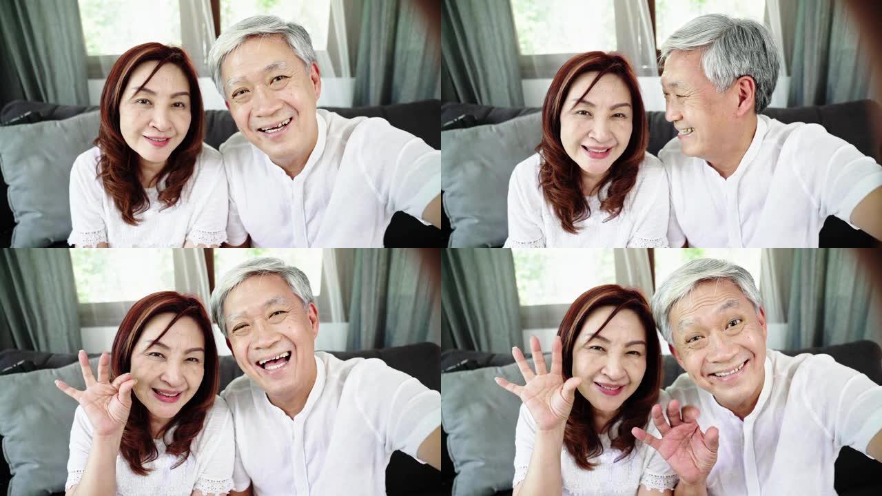 慢动作: 亚洲祖父母在沙发上看着摄像机VDO通话。