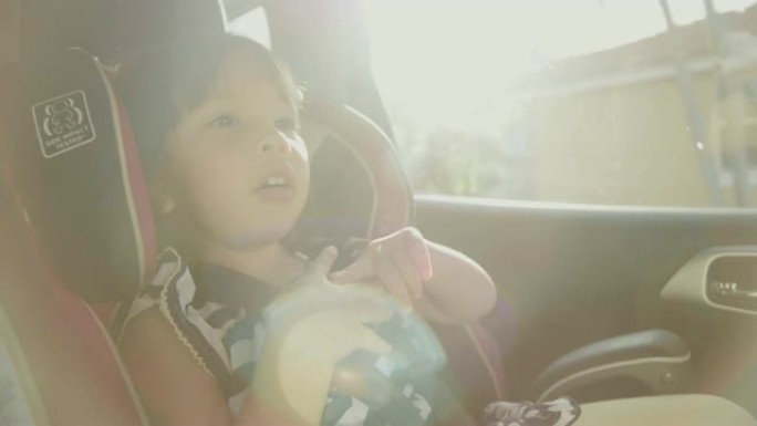 在儿童汽车安全方面。小女孩坐在一个特殊的汽车座椅上
