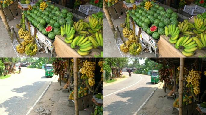 斯里兰卡路边市场摊位上展示的新鲜香蕉和西瓜女士