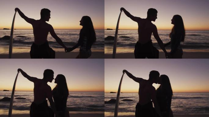 年轻的成年夫妇在日落时在海滩上放松