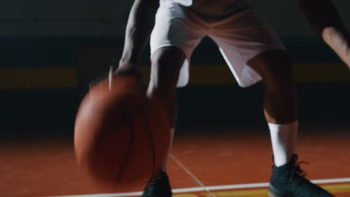 一名年轻的非洲职业男球员的电影慢动作特写镜头正在健身房用两个球练习篮球锻炼