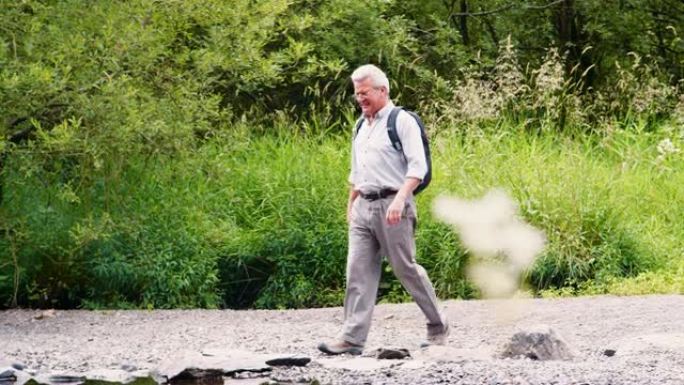 在英国湖区徒步旅行时，老人用垫脚石过河的慢动作镜头