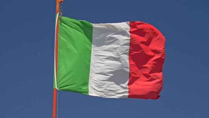 慢动作特写拍摄意大利国旗在风中挥舞。背景中的蓝天