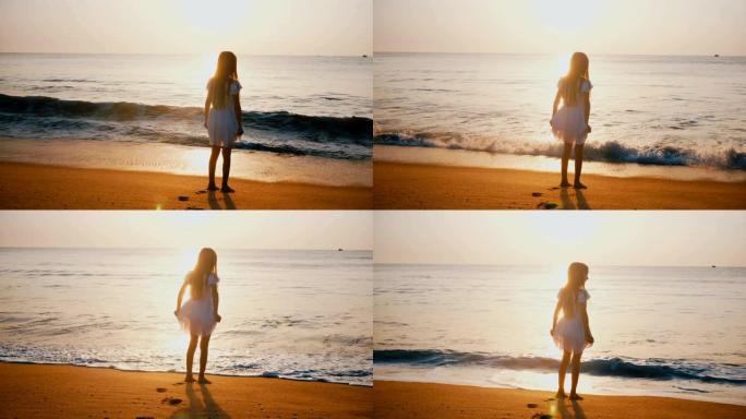 快乐兴奋的小女孩在史诗般的金日落海滩观看海浪的惊人后景拍摄。