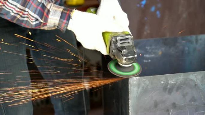4k慢动作镜头手的特写镜头使用角磨机在金属工厂、工业和机器概念中切割和研磨金属的钢零件