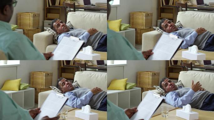 中年阿拉伯男子躺在沙发上与辅导员交谈
