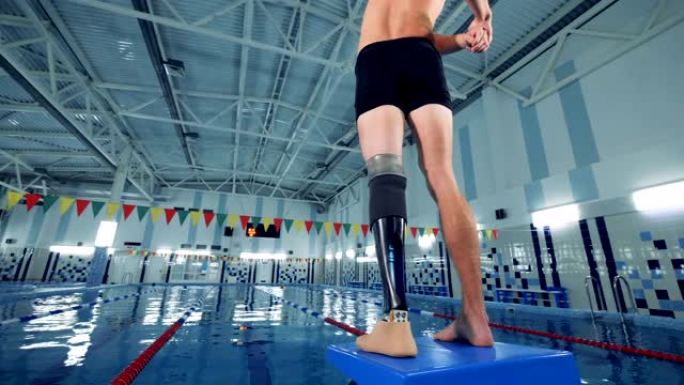 带假肢的残疾游泳者，后视图。