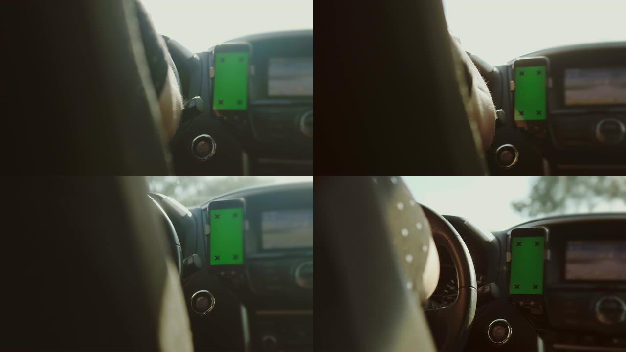 驾驶员在汽车中使用带有绿屏的智能手机，色度键