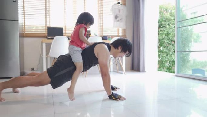 亚洲男子男子体重训练与小男孩在家新型冠状病毒肺炎。