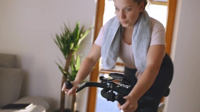 SLO MO女人在家里的健身车上锻炼