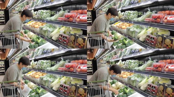 一位亚洲华人女性戴着口罩去超市买菜