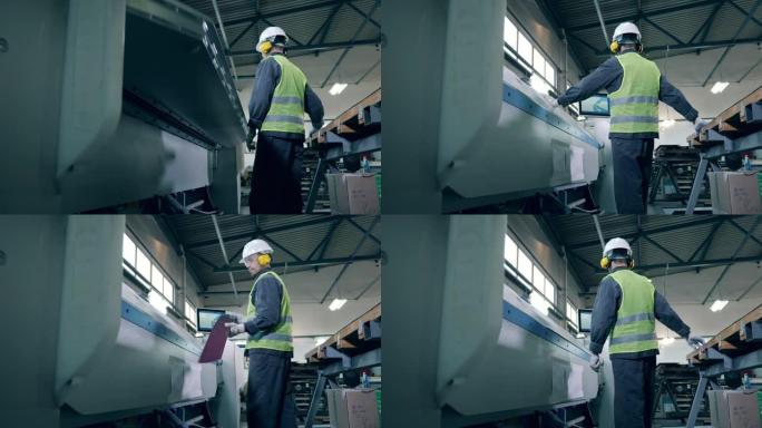 工厂工人正在用工厂机器加工金属板