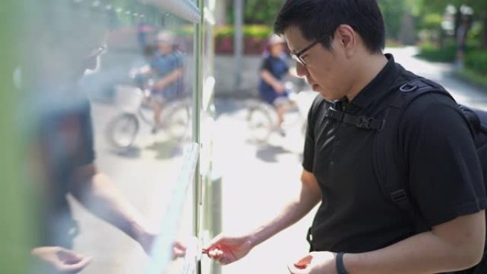 亚洲游客从自动售货机购买罐装饮料