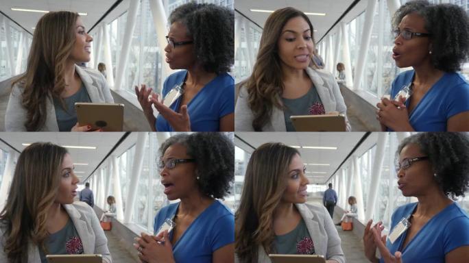 自信的女企业家在skybridge中交谈时使用数字平板电脑