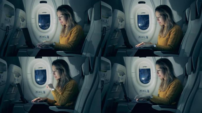 华丽的女人正在飞机机舱里的笔记本电脑上打字。在飞机内工作的女乘客。